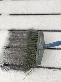 High angle view of broom cleaning snow on floor