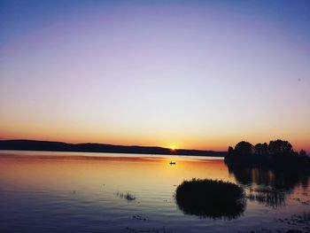 Scenic view of lake against romantic sky at sunset