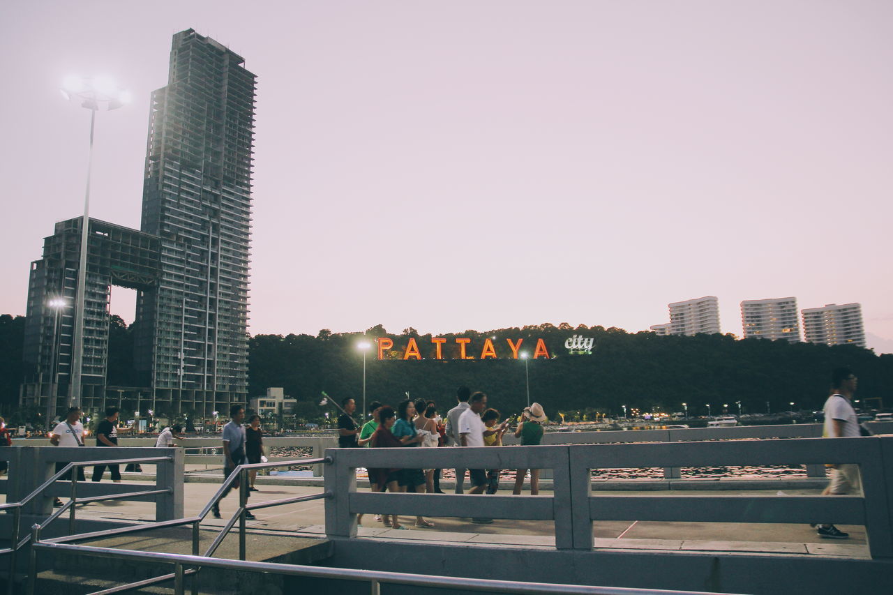 GROUP OF PEOPLE IN CITY AGAINST SKY