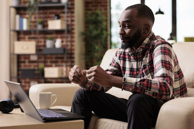 Man using laptop while sitting at cafe