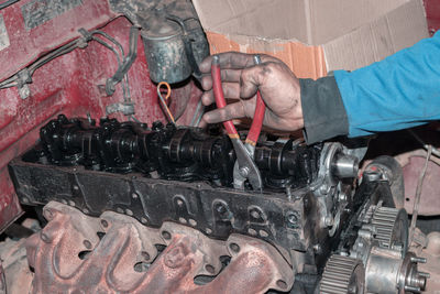 Cropped hands of man repairing car