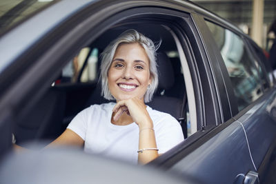 Portrait of a smiling young woman sitting in car