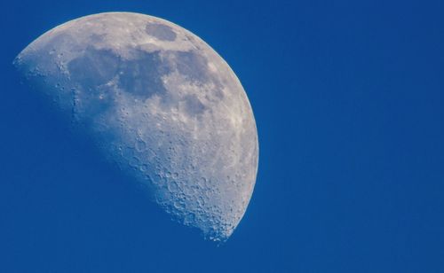 Low angle view of moon against blue sky