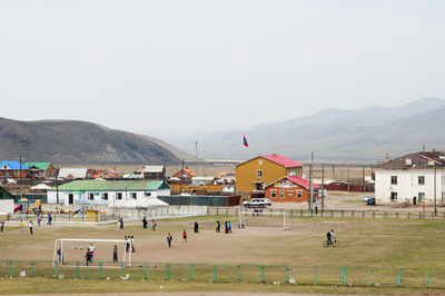 Group of people in front of buildings against sky