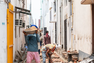 Rear view of people walking on street in city