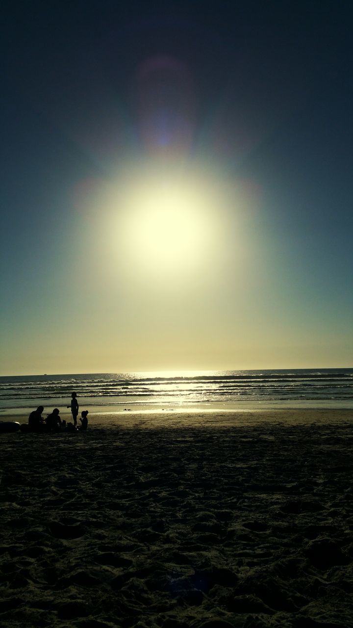 sea, horizon over water, water, beach, tranquil scene, scenics, sun, tranquility, clear sky, beauty in nature, shore, silhouette, copy space, nature, sunlight, sky, idyllic, incidental people, sunbeam, sand