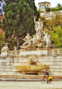 Man statue by tree in city