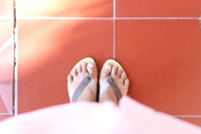 Low section of woman standing on tiled floor