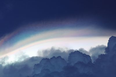 Low angle view of rainbow against cloudy sky