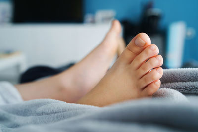 Low section of woman lying on bed