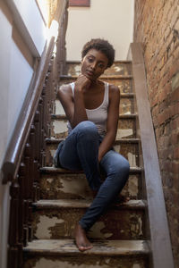 Portrait of a young woman sitting in a staircase