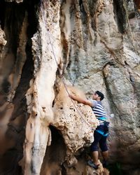 Full length of young man climbing rock