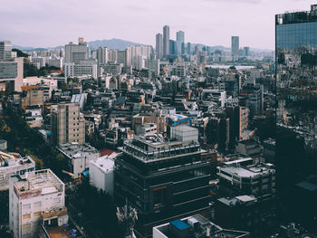 High angle view of modern buildings in city against sky