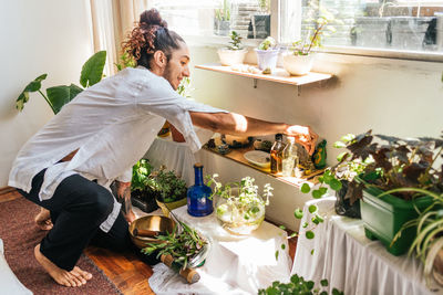 Woman standing by potted plants at restaurant table