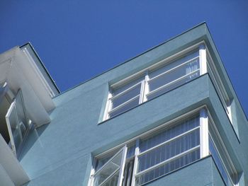 Low angle view of modern building against clear blue sky