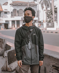 Portrait of young man standing in city