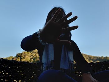 Low angle view of person against clear blue sky