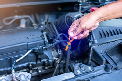 Cropped hand repairing car engine