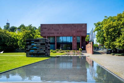 View of swimming pool by building against clear sky