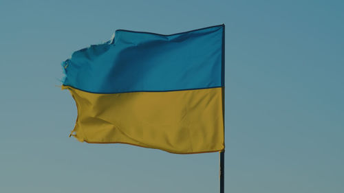 Low angle view of flag against clear sky