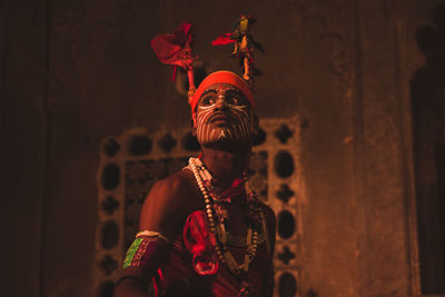 Midsection of man standing against wall