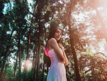 Side view of young woman in forest