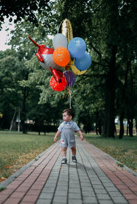 Full length of boy standing on footpath