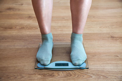 Low section of man standing on weight scale