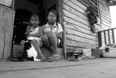 Portrait of siblings with car sitting in house