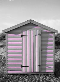 Closed wooden door of building against sky