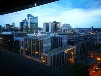 Illuminated buildings in city against sky