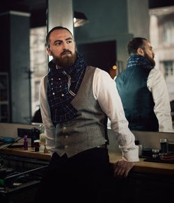 Mid adult bearded man standing in hair salon