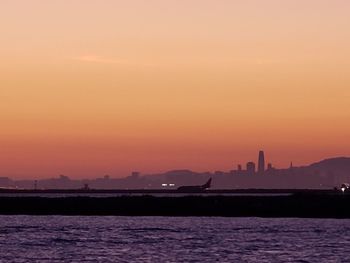 Scenic view of sea against orange sky