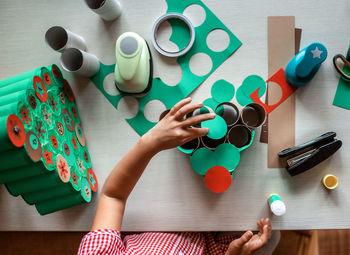 Kid making handmade advent calendar with toilet paper rolls. seasonal activity, family holidays