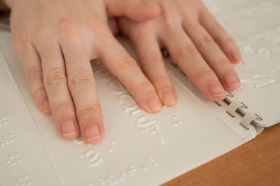 Cropped image of person reading braille language