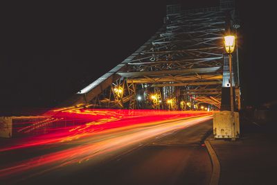 Light trails on road against sky at night