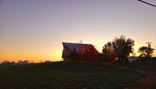 Built structure on field against clear sky during sunset