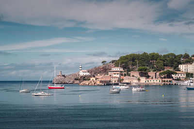 Sailboats moored on sea against sky