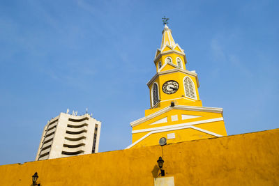 Low angle view of clock tower against blue sky