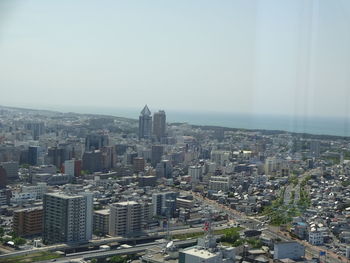 Aerial view of buildings in city against clear sky