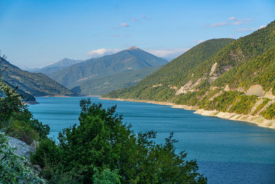 Scenic view of lake by mountains against sky