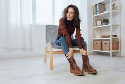 Portrait of young woman sitting on floor