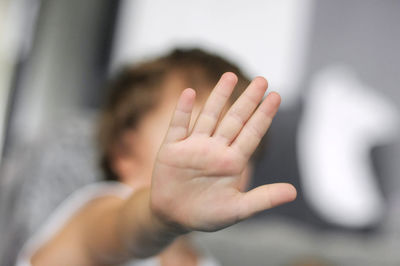 Close-up of boy gesturing stop sign