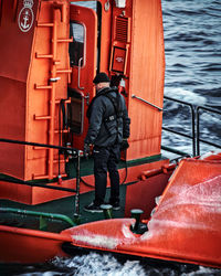 Rear view of man standing on boat