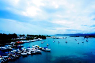 Boats in sea against cloudy sky