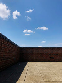 Brick wall of building against sky