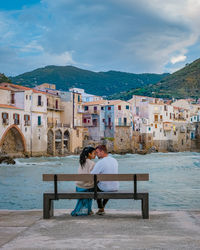Rear view of woman sitting on beach