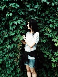 Woman standing by plants