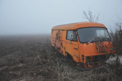 Abandoned train on field against clear sky