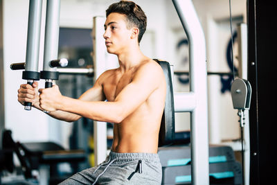 Teenage boy exercising in gym